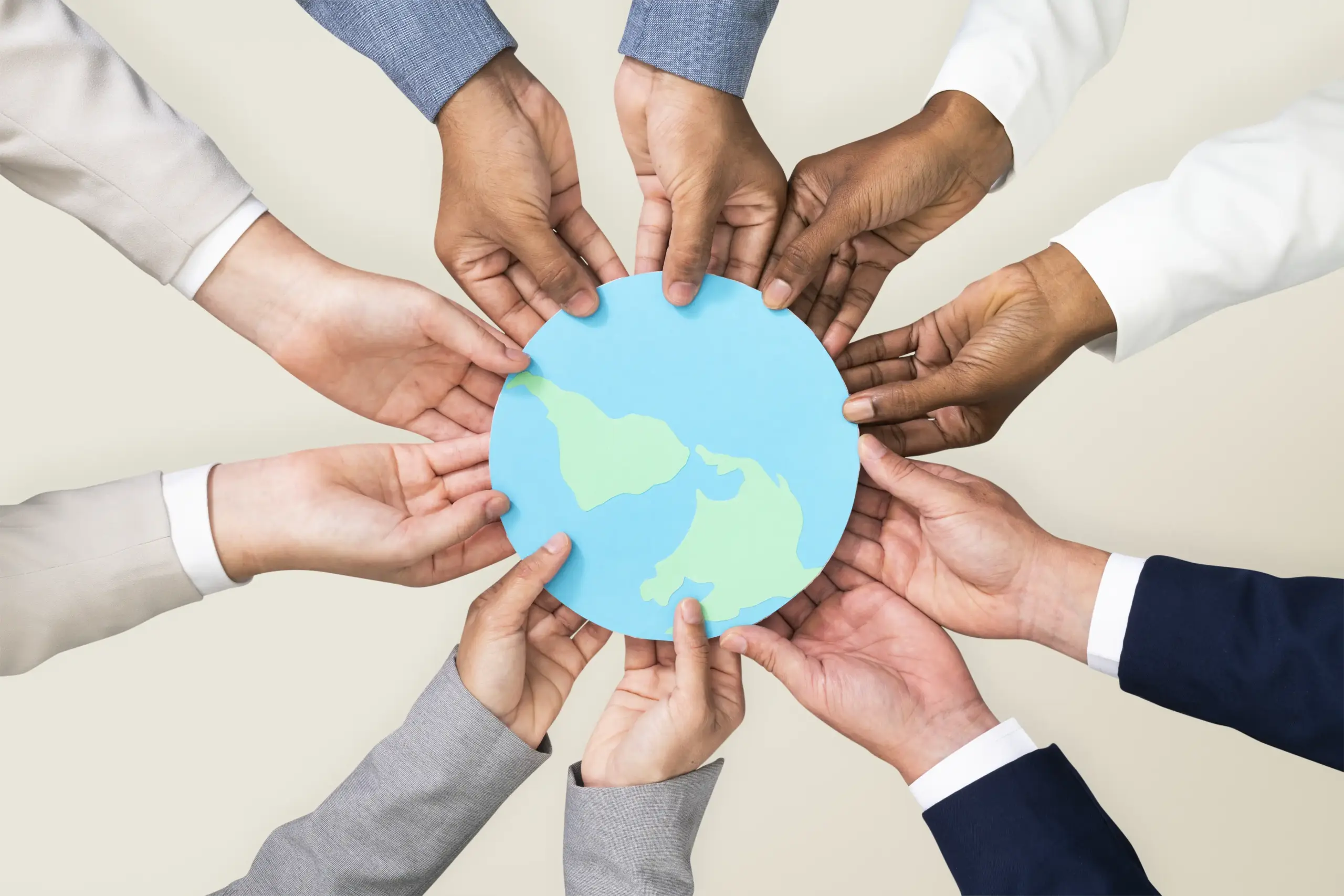 Un grupo de manos sosteniendo un papel azul con un mapa del mundo.